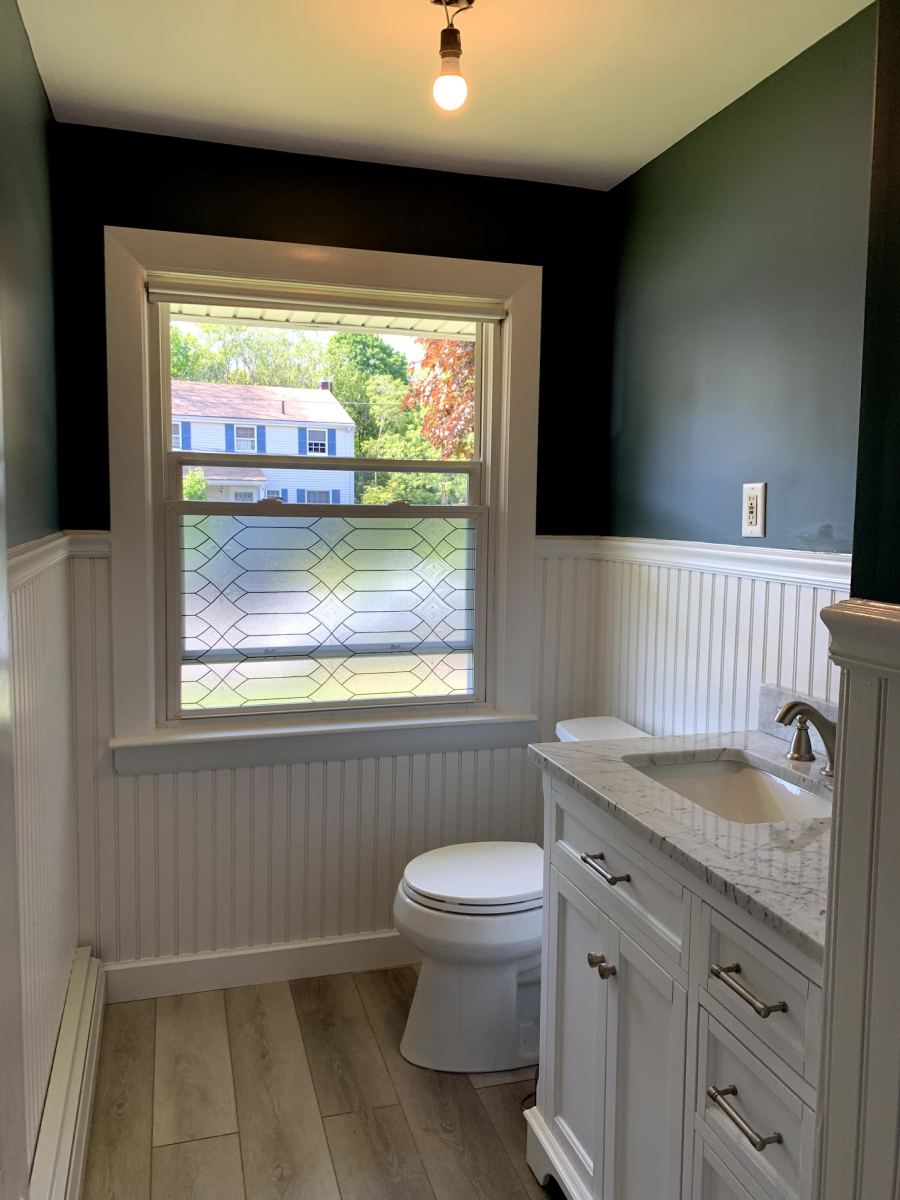 Renovated bathroom with white wainscoting, marble-top vanity and new flooring — remodeling by PRC Group in Massachusetts