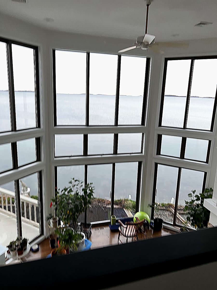 Freshly repainted two-story living room with floor-to-ceiling ocean-view windows — interior painting by PRC Group in Massachusetts